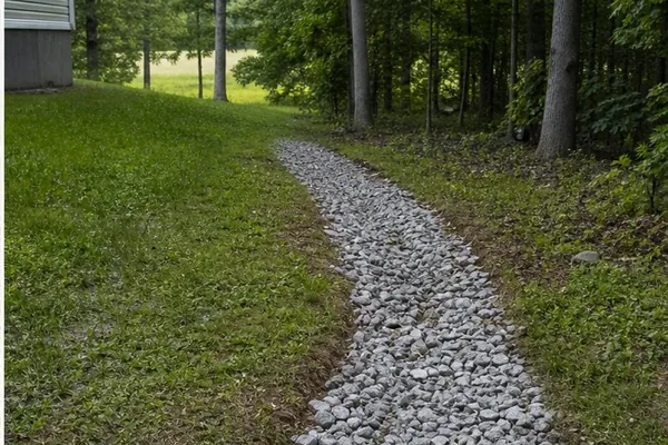 Representative stone-lined drainage area beside a home.