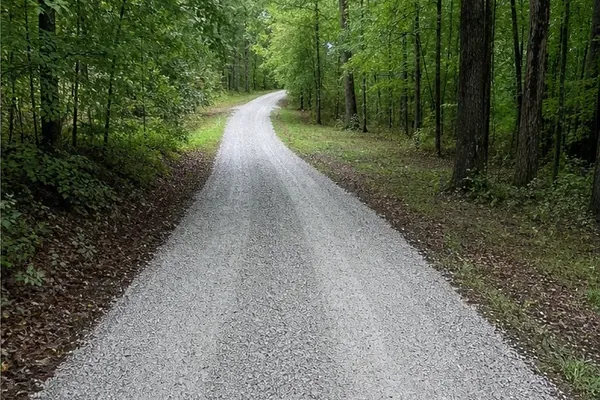 Representative gravel drive through a wooded property.